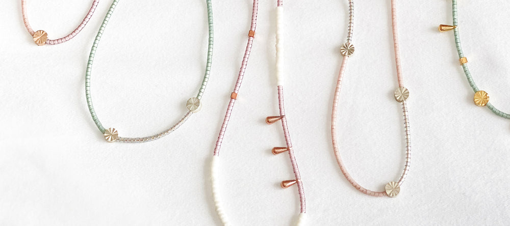 Japanese Glass Bead Necklaces by CORDA. Bits of brass dipped in silver, 18K rose gold and 22K Gold are combined with pretty glass seed beads. Dainty, delicate jewelry.